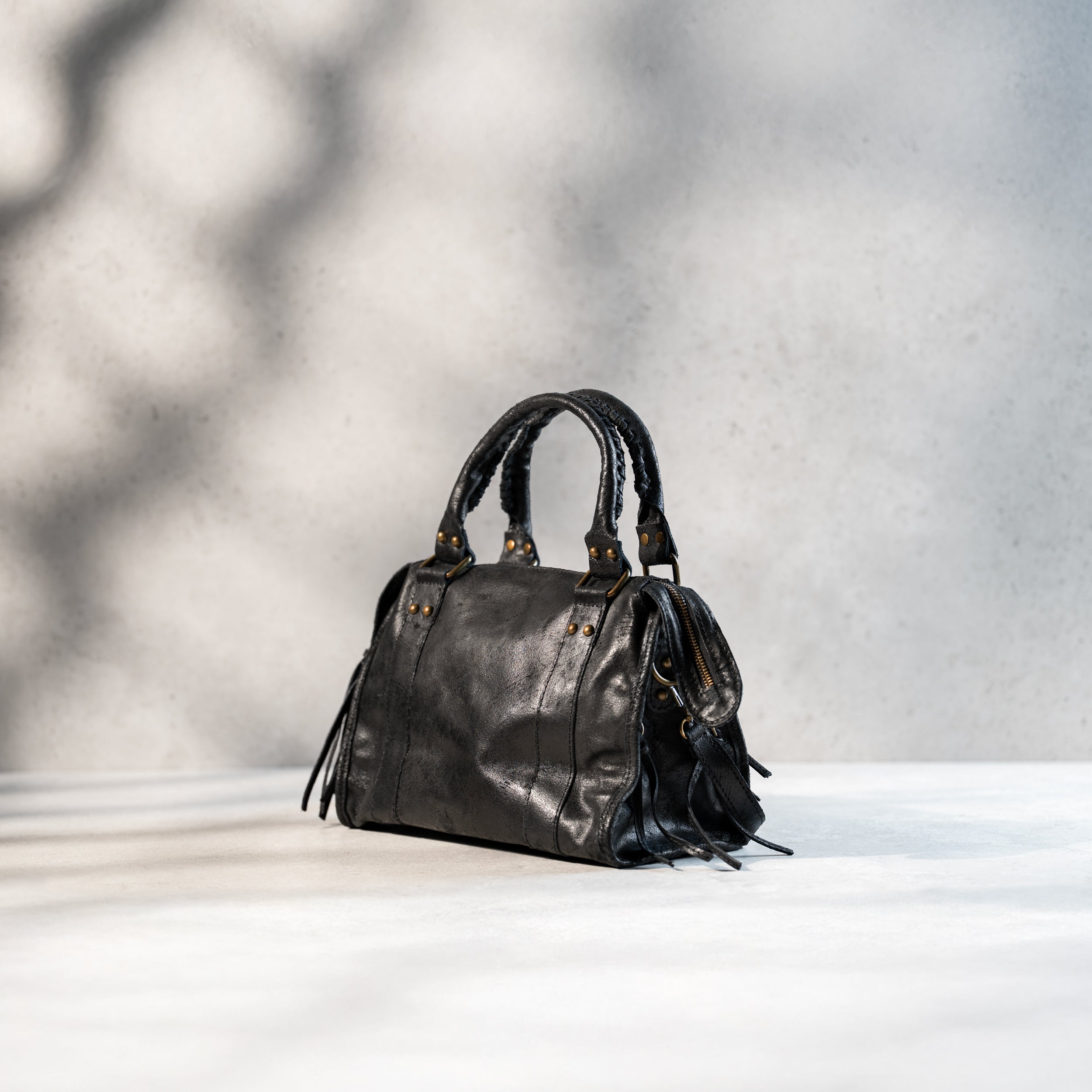 dos d'un sac à main femme forme bowling vintage en cuir vieilli noir dans un cuir de veau souple avec bijouterie en or vieilli