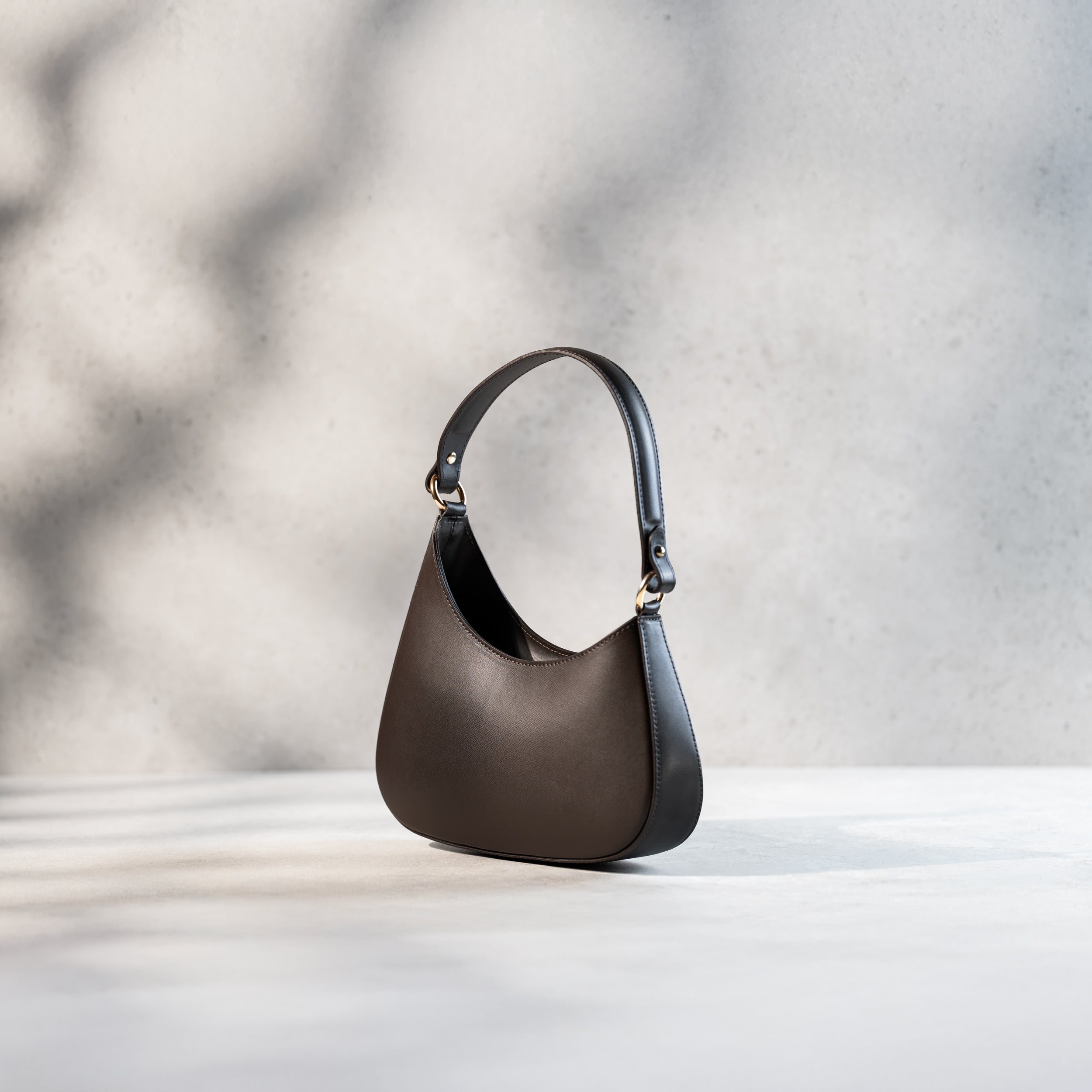 sac à main forme hobo demi lune asymétrique pour femme en cuir lisse marron de côté