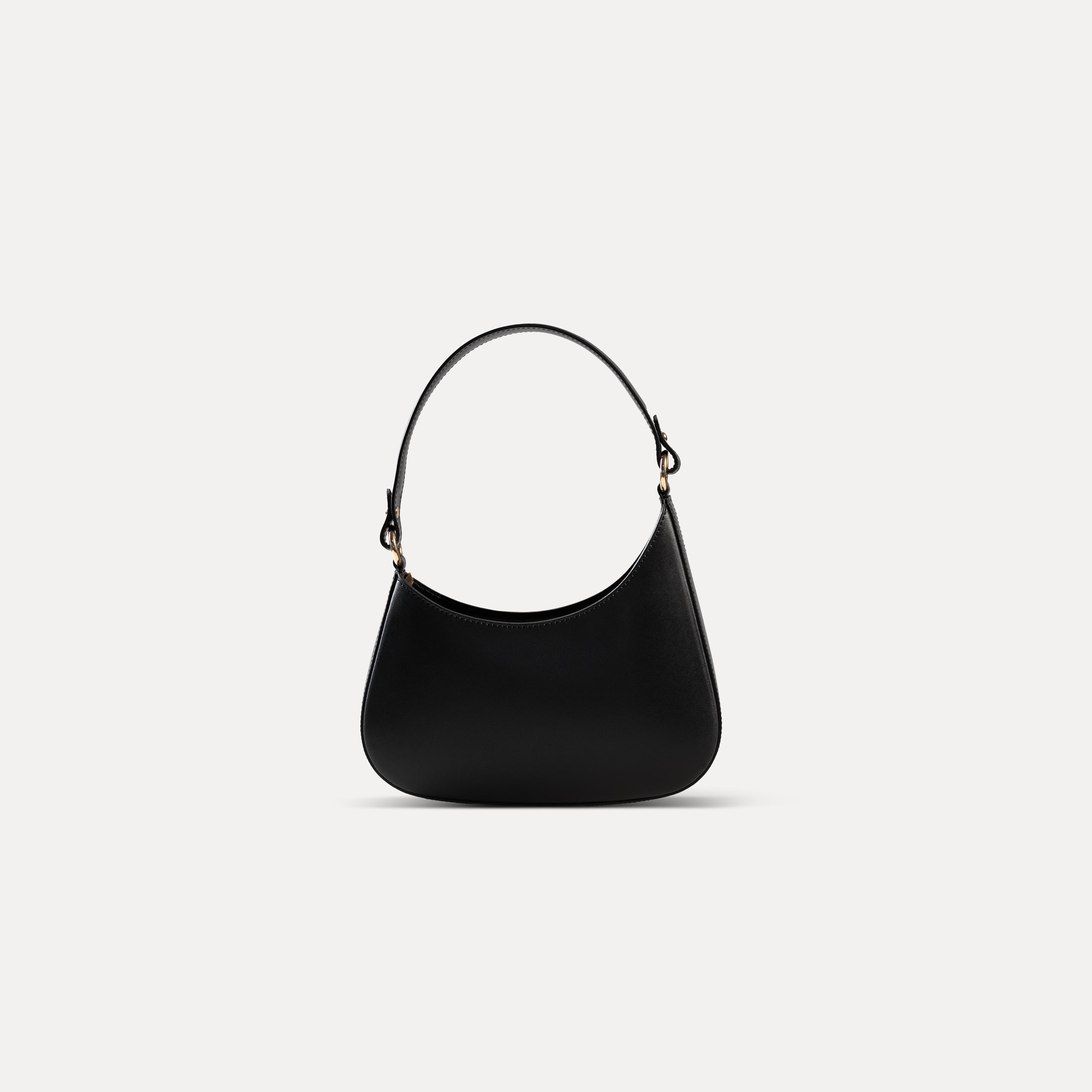 sac à main forme hobo demi lune asymétrique pour femme en cuir lisse noir avec bandoulière sur fond blanc