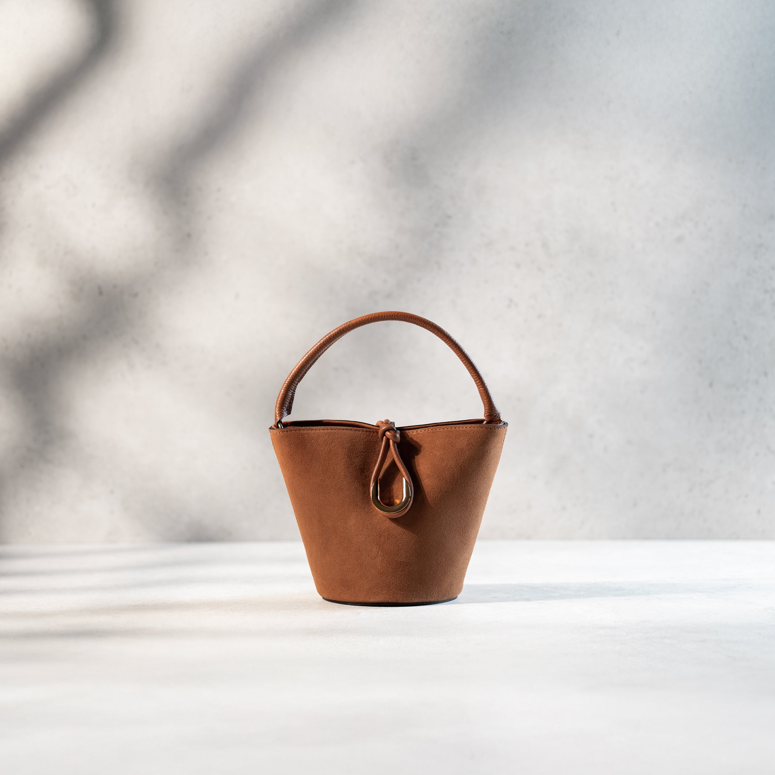 sac à main femme en cuir suédé ou daim camel en forme seau avec un fermoir doré original fermé